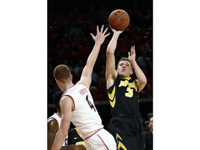 Iowa guard Jordan Bohannon, right, shoots over Maryland guard Kevin Huerter in the first half of an NCAA college basketball game in College Park, Md., Sunday, Jan. 7, 2018.