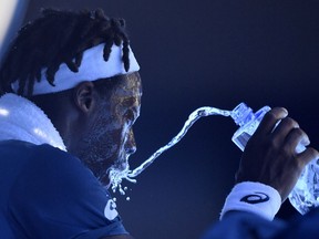 France's Gael Monfils showers himself with water during his second round match against Serbia's Novak Djokovic at the Australian Open tennis championships in Melbourne, Australia, Thursday, Jan. 18, 2018.