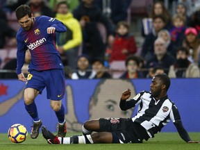 FC Barcelona's Lionel Messi, left, duels for the against Levante's Shaquell Moore during the Spanish La Liga soccer match between FC Barcelona and Levante at the Camp Nou stadium in Barcelona, Spain, Sunday, Jan. 7, 2018.