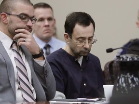 Larry Nassar sits with attorney Matt Newburg during his sentencing hearing Wednesday, Jan. 24, 2018, in Lansing, Mich. The former sports doctor who admitted molesting some of the nation's top gymnasts for years was sentenced Wednesday to 40 to 175 years in prison as the judge declared: "I just signed your death warrant."  The sentence capped a remarkable seven-day hearing in which scores of Nassar's victims were able to confront him face to face in the Michigan courtroom.