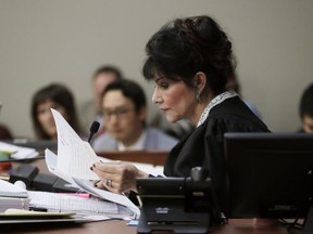 Judge Rosemarie Aquilina reads excerpts from the letter written by Larry Nassar during the seventh day of Nassar's sentencing hearing Wednesday, Jan. 24, 2018, in Lansing, Mich.  The former sports doctor who admitted molesting some of the nation's top gymnasts for years was sentenced Wednesday to 40 to 175 years in prison as Aquilina declared: "I just signed your death warrant."  The sentence capped a remarkable seven-day hearing in which scores of Larry Nassar's victims were able to confront him face to face in a Michigan courtroom.