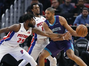 Detroit Pistons forward Reggie Bullock (25) fouls Charlotte Hornets guard Nicolas Batum (5) as Pistons guard Ish Smith, center, helps defend the basket during the first half of an NBA basketball game Monday, Jan. 15, 2018, in Detroit.