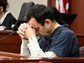 A victim makes her "impact statement" to Larry Nassar during a sentencing hearing as he puts his head down in front of Judge Rosemarie Aquilina in district court on Tuesday, Jan. 16, 2018, in Lansing, Mich. Nassar has pleaded guilty to molesting females with his hands at his Michigan State University office, his home and a Lansing-area gymnastics club, often while their parents were in the room.