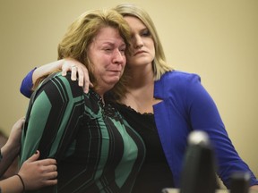 FILE- In this Jan. 22, 2018, file photo, Krista Wakeman, right, comforts her mother after Krista addressed Larry Nassar during the fifth day of victim impact statements against Nassar in Lansing, Mich.