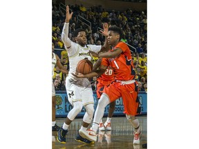 Michigan guard Zavier Simpson, left, defends against Illinois guard Trent Frazier (1) during the first half of an NCAA college basketball game at Crisler Center in Ann Arbor, Mich., Saturday, Jan. 6, 2018.