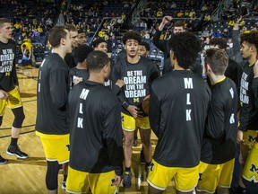 Michigan guard Jordan Poole, center, leads teammates in a huddle during warmups before an NCAA college basketball game against Maryland at Crisler Center in Ann Arbor, Mich., Monday, Jan. 15, 2018. Michigan wore special warmup tees honoring Martin Luther King Jr.