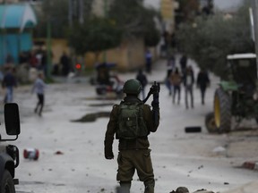 Palestinians clash with Israeli troops in the West Bank city of Jenin, Thursday, Jan. 18, 2018. Israeli police say special forces killed a Palestinian gunman in the West Bank who allegedly killed an Israeli in a drive-by shooting earlier this month.