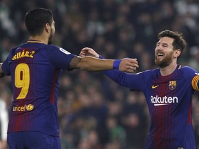 Barcelona's Messi, right, celebrates with teammate Suarez after scoring against Betis during the La Liga soccer match between Barcelona and Betis at the Villamarin stadium, in Seville, Spain on Sunday, Jan. 21, 2018.