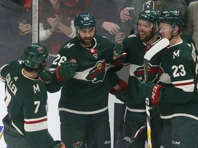 Minnesota Wild's Daniel Winnik, second from left, is congratulated by teammates after his goal off Buffalo Sabres goalie Robin Lehner of Sweden in the first period of an NHL hockey game Thursday, Jan. 4, 2018, in St. Paul, Minn.