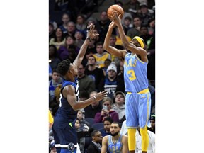 Los Angeles Lakers' Corey Brewer, right, shoots over Minnesota Timberwolves' Jimmy Butler in the first half of an NBA basketball game Monday, Jan. 1, 2018, in Minneapolis.