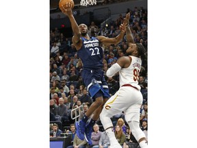 Minnesota Timberwolves' Andrew Wiggins, left, lays up a shot as Cleveland Cavaliers' Jae Crowder defends in the first half of an NBA basketball game Monday, Jan. 8, 2018, in Minneapolis.