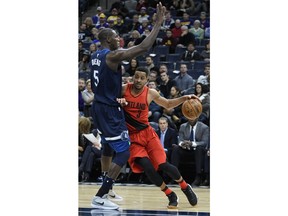 Portland Trail Blazers' C.J. McCollum, right, attempts to drive around the Minnesota Timberwolves' Gorgul Dieng, left, in the half of an NBA basketball game Sunday, Jan. 14, 2018, in Minneapolis.