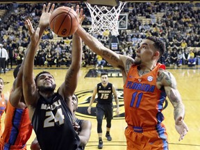 Missouri's Kevin Puryear (24) and Florida's Chris Chiozza (11) reach for a rebound during the first half of an NCAA college basketball game Saturday, Jan. 6, 2018, in Columbia, Mo.