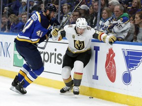 St. Louis Blues' Robert Bortuzzo (41) and Vegas Golden Knights' Cody Eakin (21) chase after a loose puck along the boards during the first period of an NHL hockey game Thursday, Jan. 4, 2018, in St. Louis.