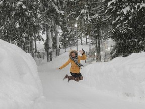 A woman jumps up for a photo in the snow near the congress center where the World Economic Forum, WEF, will take place in Davos, Switzerland, Monday, Jan. 22, 2018. The meeting brings together entrepreneurs, scientists, chief executives and political leaders from Jan. 23 to 26.