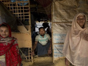 In this Tuesday, Jan. 23, 2018, photo, Abdul Gaffar, 50, center, who is third time refugee, poses for a photograph with his wife, right, and daughter in his make shift shelter at BaluKhali refugee camp 50 kilometers (32 miles) from, Cox's Bazar, Bangladesh, Tuesday, Jan. 23, 2018. "I have no intention to go back this time," said the 50-year-old who had fled to Bangladesh in 1978 and in 1991, returning both times for the love of his country.
