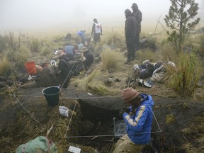 In this 2016 photo provided by Mexico's National Institute of Anthropology and History, INAH, researchers excavate a site on the shores of Nahualac Lagoon, at the foot of the Iztaccihuatl volcano in Mexico State, Mexico. Mexican archaeologists say they have excavated a stone sanctuary in a pond on the side of a volcano east of Mexico City that may have been built as a miniature model of the universe.