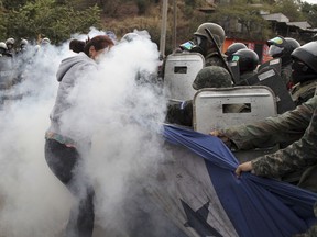 Supporters of opposition presidential candidate Salvador Nasralla struggle with military police for possession of a giant Honduran flag at the Policarpo Paz Garcia neighborhood of Tegucigalpa, Honduras, Saturday, Jan. 20, 2018. Following a disputed election marred by irregularities, incumbent President Juan Orlando Hernandez was declared the victor and will be inaugurated on Jan. 27. The opposition does not recognize Hernandez's victory and are protesting against the result.