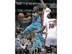 Charlotte Hornets' Kemba Walker (15) drives past Miami Heat's Josh Richardson (0) and James Johnson (16) during the first half of an NBA basketball game in Charlotte, N.C., Saturday, Jan. 20, 2018.