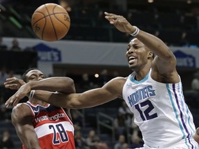 Charlotte Hornets' Dwight Howard (12) is fouled by Washington Wizards' Ian Mahinmi (28) during the first half of an NBA basketball game in Charlotte, N.C., Wednesday, Jan. 17, 2018.