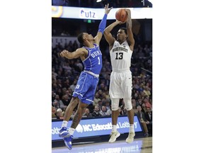 Wake Forest's Bryant Crawford (13) shoots over Duke's Trevon Duval (1) during the first half of an NCAA college basketball game in Winston-Salem, N.C., Tuesday, Jan. 23, 2018.