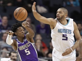 Sacramento Kings' De'Aaron Fox, left, passes the ball past Charlotte Hornets' Nicolas Batum, right, during the first half of an NBA basketball game in Charlotte, N.C., Monday, Jan. 22, 2018.