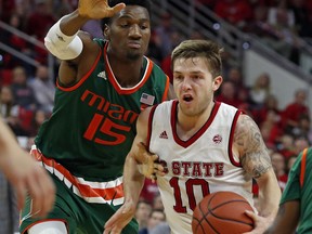 North Carolina State's Braxton Beverly (10) drives the ball past Miami's Ebuka Izundu (15) during the first half of an NCAA college basketball game in Raleigh, N.C., Sunday, Jan. 21, 2018.