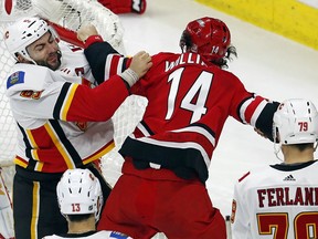 Carolina Hurricanes' Justin Williams (14) exchanges blows with Calgary Flames' Mark Giordano (5) during the third period of an NHL hockey game, Sunday, Jan. 14, 2018, in Raleigh, N.C.