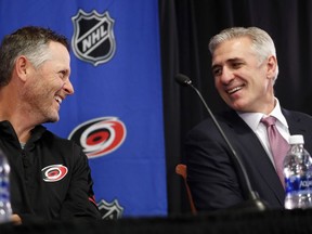 Carolina Hurricanes new NHL hockey team majority owner Thomas Dundon, left, chats with team general manager Ron Francis during an introductory press conference at PNC Arena in Raleigh, N.C., Friday, Jan. 12, 2018.