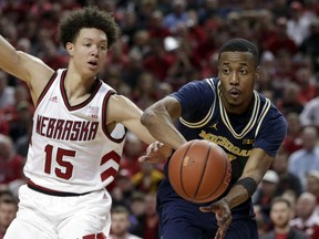 Michigan's Muhammad-Ali Abdur-Rahkman, right, passes the ball while defended by Nebraska's Isaiah Roby (15) during the first half of an NCAA college basketball game in Lincoln, Neb., Thursday, Jan. 18, 2018.