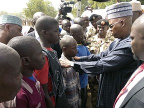 In this Monday, Jan.15, 2018, photo, Borno State Gov. Kashim Shettima, second right, speaks with people freed by Nigeria Army, in Maiduguri Nigeria. Nigeria's army released 244 Boko Haram suspects who have denounced their membership of the deadly extremist group, Nigerian army officials said Tuesday.