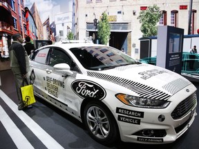 An attendee looks at Ford's self-driving delivery vehicle at CES International, Tuesday, Jan. 9, 2018, in Las Vegas.