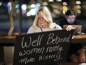 In this Jan. 17, 2018, photo, Jeri Burton makes a sign in preparation for a rally in Las Vegas. A year after more than 1 million people rallied at women's marches around the world with a message of female empowerment and protest of President Donald Trump, organizers will mark the anniversary with more than a hundred marches around the world and a rally in Las Vegas aiming to channel the activism to register voters and swing elections for progressives this year.