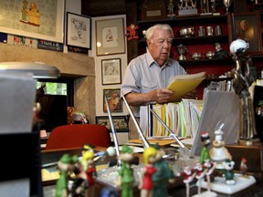 FILE - In this Aug. 16, 2010 file photo, Mort Walker, the artist and author of the Beetle Bailey comic strip, looks over notes and documents in his studio in Stamford, Conn. On Saturday, Jan. 27, 2018, a family member said the comic strip artist has died. He was 94.