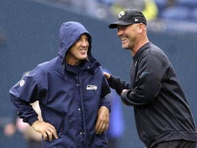 FILE - In this Sept. 22, 2013, file photo, Seattle Seahawks head coach Pete Carroll, left, and Jacksonville Jaguars head coach Gus Bradley talk in the rain before an NFL football game in Seattle. The scheme that carried the Seahawks to consecutive Super Bowls (2013-14) has become increasingly popular around the league. It helped Atlanta get to the big game last year and was the catalyst for Jacksonville's stunning turnaround this season.