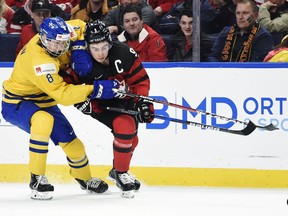 FILE - In this Jan. 5, 2018, file photo, Sweden defenseman Rasmus Dahlin, left, and Canada forward Dillon Dube vie for the puck during the first period of the title game of the IIHF world junior hockey championships in Buffalo, N.Y. One of the most dynamic and offensively talented players set to play in the Olympics is also the youngest: Dahlin, who's projected to be the No. 1 pick in the NHL draft in June. Dahlin has 11 points in 29 games playing against grown men in the Swedish Hockey League and had six points in seven games at the world juniors. He's just 17.