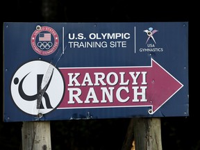 In this Sept, 12, 2015 photo, a sign points down the road to the Karolyi Ranch near New Waverly, Texas. Texas Gov. Greg Abbott on Tuesday, Jan. 30, 2018, has ordered a criminal investigation into claims that former doctor Larry Nassar abused some of his victims at the Texas ranch that was the training ground for U.S. women's gymnastics .