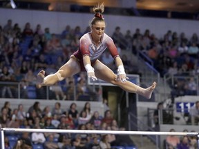 FILE- In this April 15, 2017, file photo, Oklahoma's Maggie Nichols competes on the uneven parallel bars during the NCAA college women's gymnastics championships in St. Louis. Nichols, a former Olympic hopeful, says she is among more than 100 women and girls who say they are victims of sexual abuse by a now-imprisoned Michigan sports doctor. She said in a statement Tuesday, Jan. 9, 2018, that Dr. Larry Nassar violated her innocence at the Karolyi Ranch Olympic training camp in Texas.