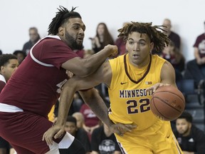 FILE - In this Friday, Nov. 24, 2017 file photo, Minnesota center Reggie Lynch (22) drives to the basket against UMass center Rashaan Holloway during the first half of an NCAA college basketball game in New York. Minnesota basketball player Reggie Lynch has been recommended for expulsion following a newly public allegation of sexual assault. The Star Tribune and the St. Paul Pioneer Press report the university's Equal Opportunity and Affirmative Action office found Lynch responsible for sexual misconduct in an alleged assault April 7, 2016. Both newspapers say they obtained a Jan. 3, 2018 finding by the office.