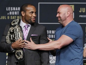 FILE - In this July 6, 2016, file photo, Dana White, right, President of the Ultimate Fighting Championship, holds back Daniel Cormier during a UFC 200 mixed martial arts news conference in Las Vegas. Cormier is pumped to defend his UFC light heavyweight championship and says he can beat Volkan Oezdemir. They will fight at UFC 220 on Jan. 20, 2018, in Boston.