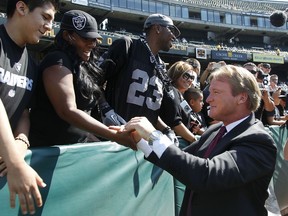 FILE - In this Aug. 13, 2012, file photo, NFL broadcaster and former Oakland Raiders head coach Jon Gruden greets fans before an NFL preseason football game between the Raiders and the Dallas Cowboys in Oakland, Calif. The Oakland Raiders are set to bring Jon Gruden back for a second stint as coach. A person with knowledge of the team's plans said the Raiders are planning a news conference Tuesday to announce that Gruden is leaving the broadcast booth to come back to coaching. The person spoke on condition of anonymity because the team has made no formal announcement.