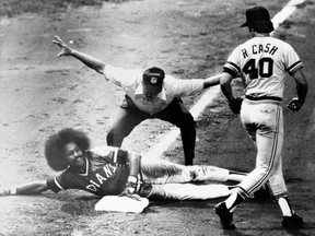 FILE - In this Sept. 10, 1974, file photo, Cleveland Indians' Oscar Gamble flashes a smile after sliding safely into third in the sixth inning of baseball game against the Detroit Tigers in Cleveland, Ohio, Sept. 10, 1974. Gamble doubled and made it to third on an outfield error. Detroit's Ron Cash watches as umpire Bill Kunkel flashes the safe signal. Gamble, an outfielder who hit 200 home runs over 17 major league seasons, died Wednesday, Jan. 31, 2018, of a rare tumor of the jaw. He was 68. (AP Photo/File)