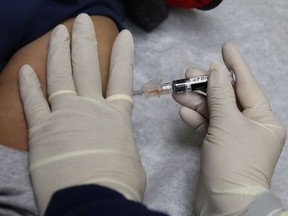 Ana Martinez, a medical assistant at the Sea Mar Community Health Center, gives a patient a flu shot, Thursday, Jan. 11, 2018 in Seattle. According to an update by the Centers for Disease Control and Prevention released Friday, Jan. 12, 2018, flu is now widespread in every state except Hawaii, but the good news is the flu season appears to be peaking.