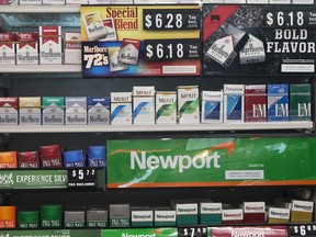 FILE - In this Thursday, May 18, 2017 file photo, packs of cigarettes are offered for sale at a convenience store in Helena, Mont. Tobacco companies have made claims about "safer" cigarettes since the 1950s, all later proven false. In some cases the introduction of these products, such as filtered and "low tar" cigarettes, propped up cigarette sales and kept millions of Americans smoking. Although the adult smoking rate has fallen to an all-time low of 15 percent in 2017, smoking remains the nation's leading preventable cause of death and illness, responsible for about one in five U.S. deaths.