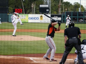 FILE - In this March 3, 2015, file photo, Detroit Tigers pitcher Kyle Lobstein, left, delivers his first pitch of the second inning to Baltimore Orioles' Matt Tulasosopo as the clock, background, counts down during a spring training exhibition baseball game in Lakeland, Fla. Major League Baseball has proposed the use of 20-second pitch clocks and limits on mound visits, a move that dares management to unilaterally impose the changes designed to speed pace of games.