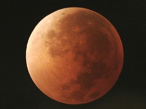 FILE - In this Aug. 28, 2007, file photo, the moon takes on different orange tones during a lunar eclipse seen from Mexico City. During a lunar eclipse, the moon's disk can take on a colorful appearance from bright orange to blood red to dark brown and, rarely, very dark gray. On Wednesday, Jan. 31, 2018, a super moon, blue moon and a lunar eclipse will coincide for first time since 1982 and will not occur again until 2037.