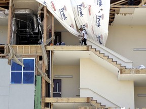 FILE - In this Sept. 2, 2017, file photo, workers pick up debris in a staircase of a four-story hotel exposed when the wall fell during Hurricane Harvey, in Rockport, Texas. Texas coastal towns where Hurricane Harvey made landfall are working to restore tourism and other economic attractions nearly five months after the storm.