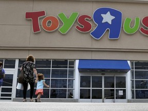 FILE - In this Sept. 19, 2017, file photo, shoppers walk into a Toys R Us store, in San Antonio. Toys R Us says it will be closing some U.S. stores and converting others to cobranded locations as it continues to deal with its financial restructuring following its bankruptcy filing.