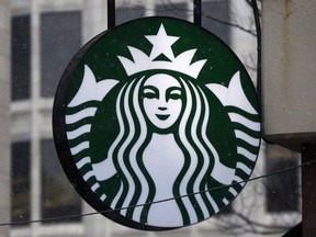 FILE - This Tuesday, March 14, 2017, file photo shows the Starbucks logo on a shop in downtown Pittsburgh. Starbucks is giving its U.S. workers pay raises and stock bonuses in 2018, citing recent tax reform. The coffee chain is also extending the potential to earn paid sick time off to all employees, and is boosting its parental leave benefits.