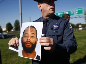 FILE - In this Oct. 18, 2017 file photo, Harford County Sheriff Jeffrey Gahler displays a photo of Radee Prince, the suspect in a shooting at a business park in the Edgewood area of Harford County, Md. Prince, accused of fatally shooting three co-workers and wounding three other people, has been indicted in Maryland.  The Harford County State's Attorney's office said in a statement that Prince was indicted Tuesday, Jan. 2, 2018, on three counts of first-degree murder, two counts of attempted first-degree murder, and firearm offenses.